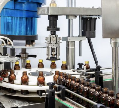 Sterile bottles on the production line conveyor of the pharmaceutical industry. Machine for iquid drugs glassware bottling.